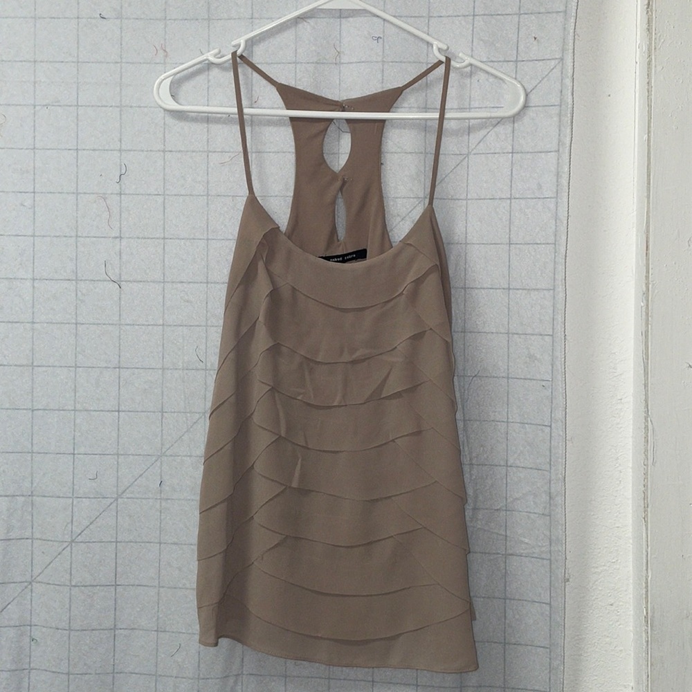 Tan tank with scalloped edges with a frayed texture. Cutout button back.